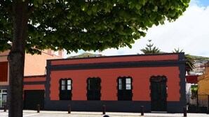 Un edificio con fachada roja y negra, ventanas y puertas.