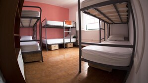 Un dormitorio con literas, cajones de madera y una ventana con persianas.