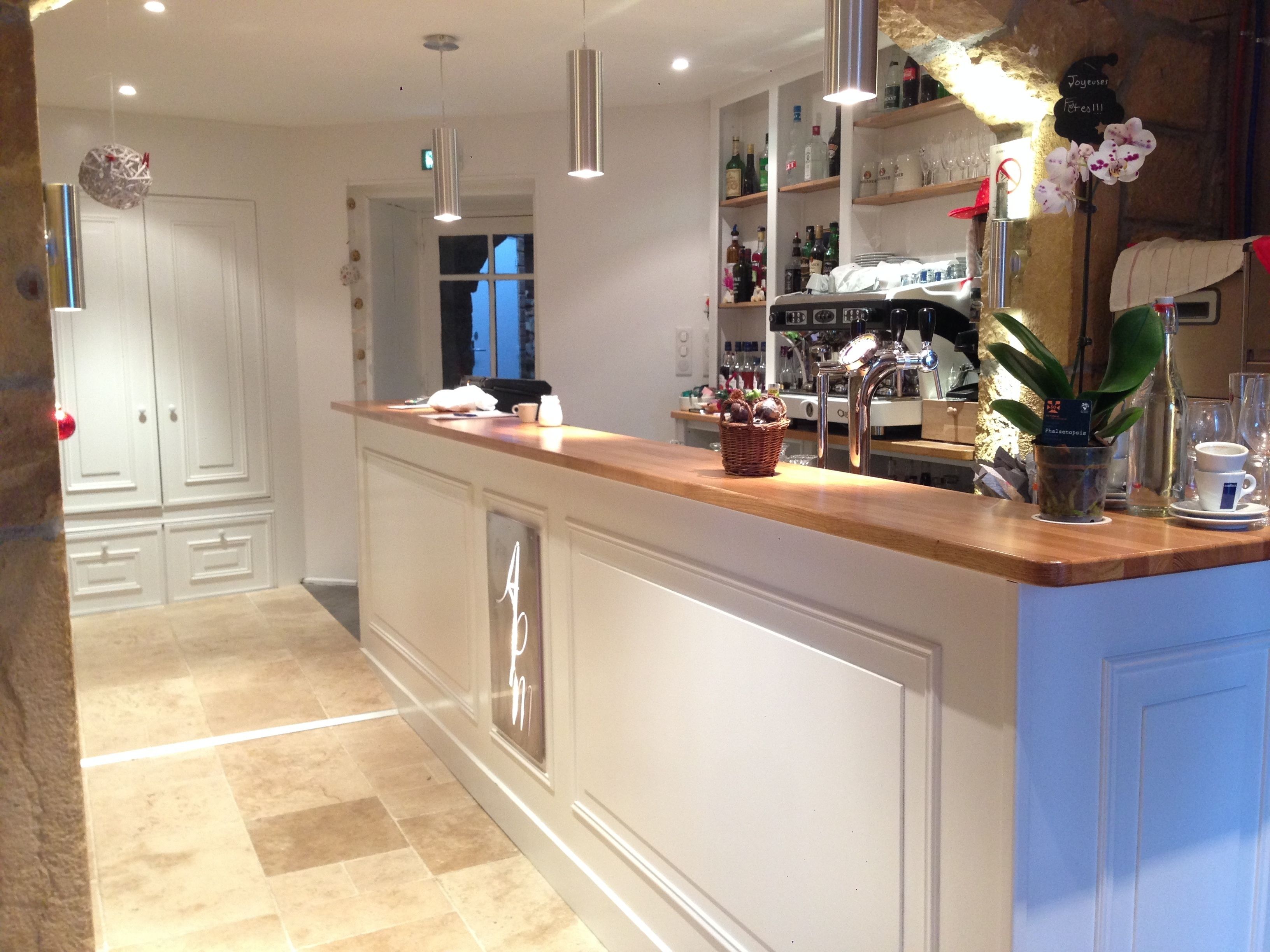 A modern kitchen with a central island, white cabinetry, and a variety of kitchen appliances.
