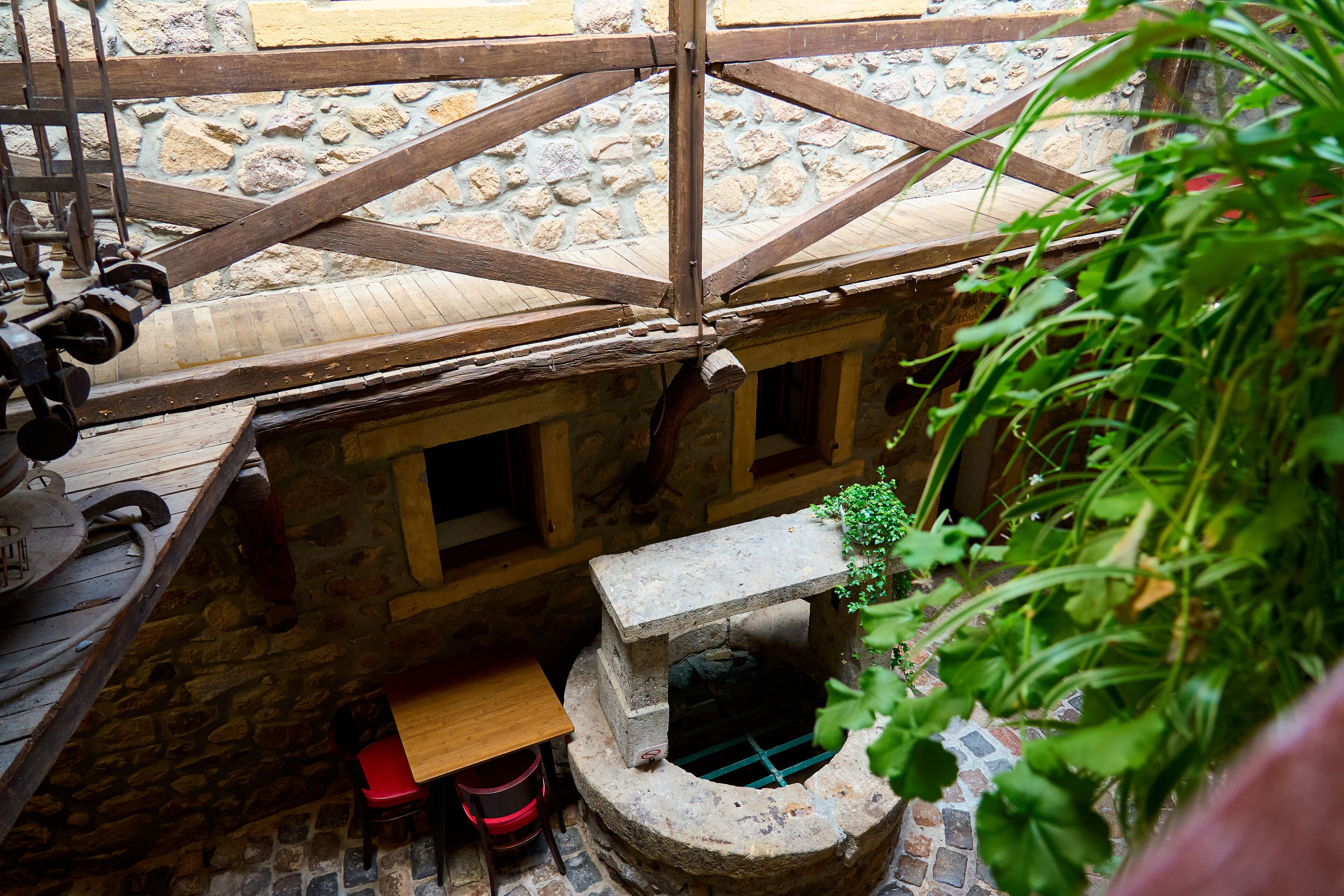 A rustic stone structure with a wooden roof, a small window, and a stone bench.