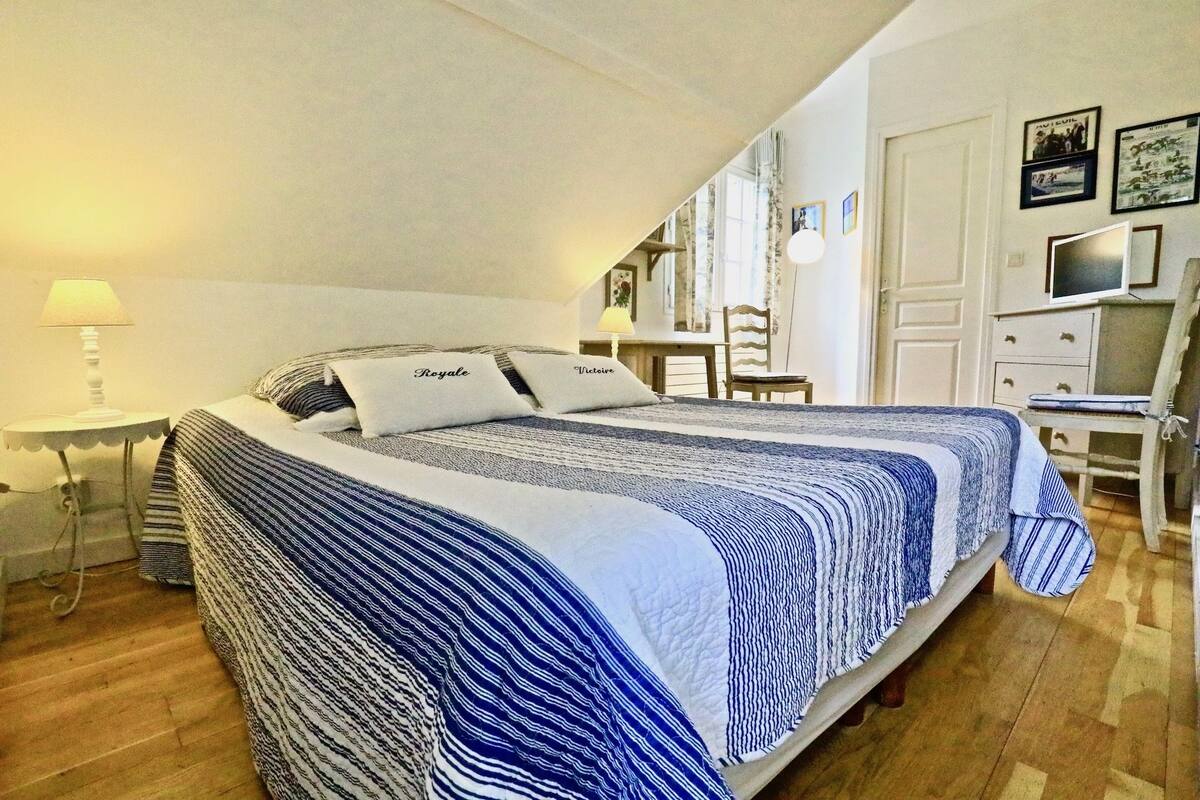 Un dormitorio con dos camas, un escritorio y una silla.