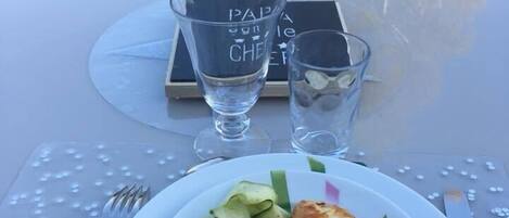 A table set with a plate of food, a glass, and a menu.