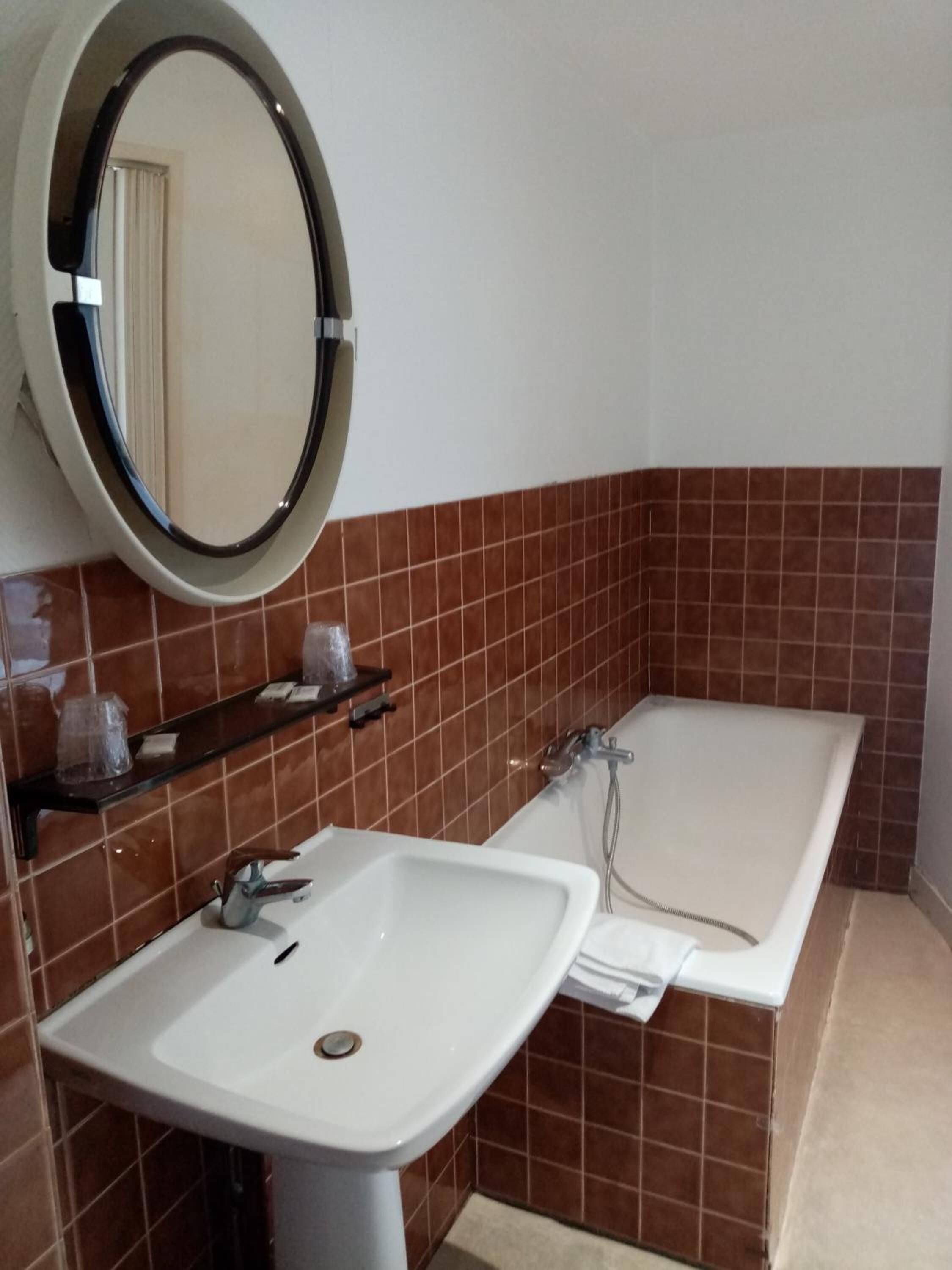 A bathroom with a white sink, a mirror, and a bathtub.