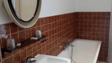 A bathroom with a white sink, a mirror, and a bathtub.