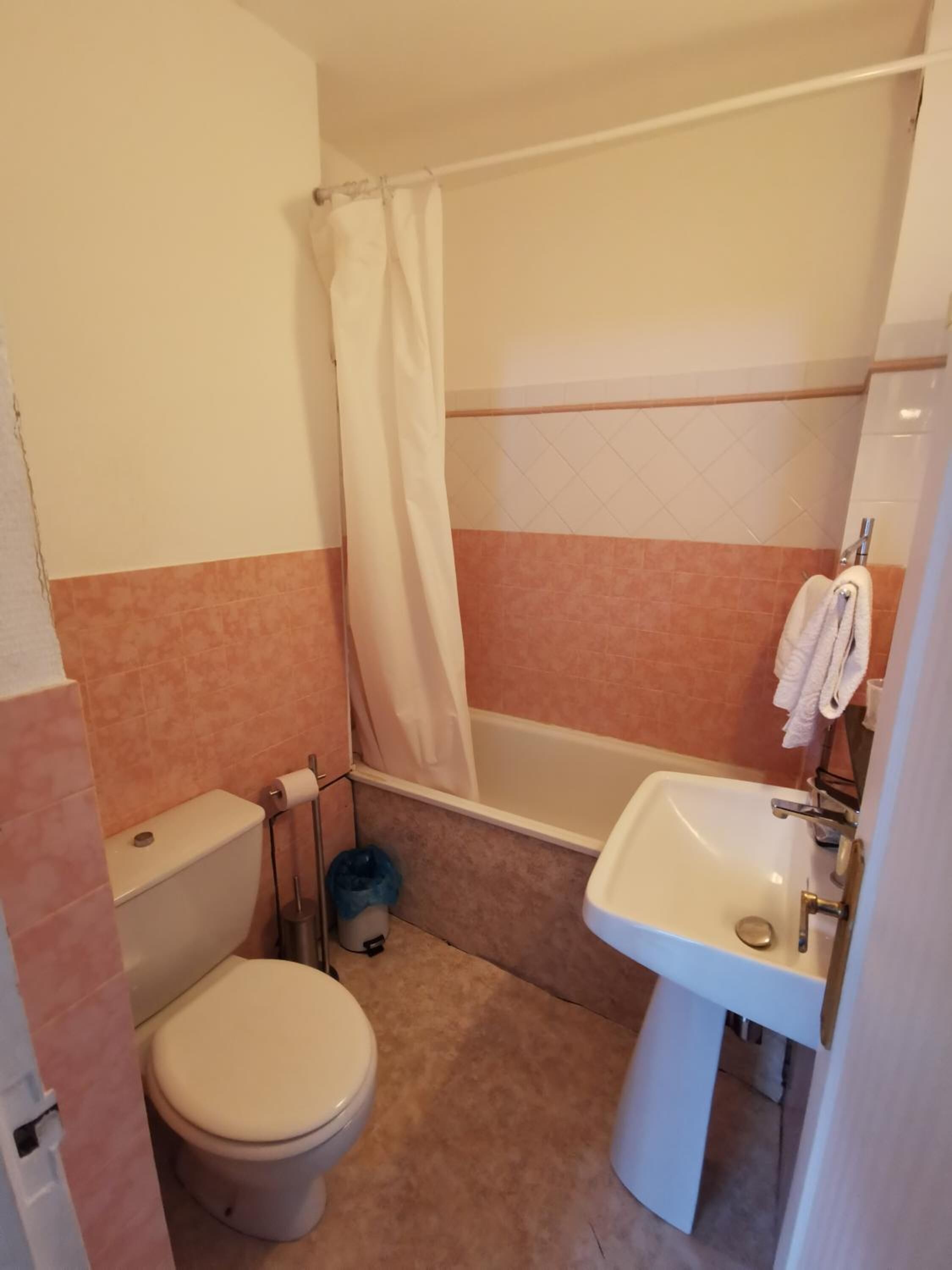 A small bathroom with a toilet, a bathtub, and a sink.