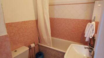 A small bathroom with a toilet, a bathtub, and a sink.