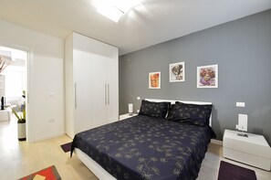 A bedroom with a bed, nightstands, a wardrobe, and wall art. - Venetian Dream in Biennale Area by Wonderful Italy (Venice)