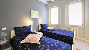 A room with two beds, a small table, a mirror, and a window. - Venetian Dream in Biennale Area by Wonderful Italy (Venice)