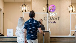A reception desk at a hotel with a sign that reads "Coast Hotels." - Coast Oliver Hotel (Oliver)
