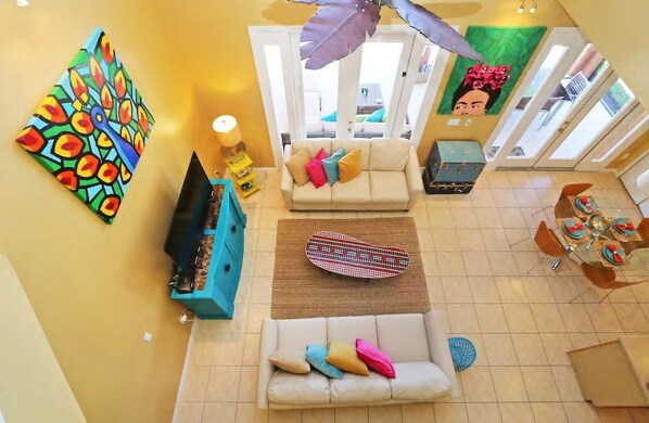 A spacious living area with a sofa, a coffee table, and a dining table set for four.