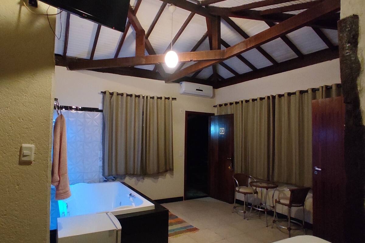 A hotel room with a bed, a TV, a desk, and a chair.