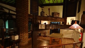 A cozy, multi-level living space with a wooden floor, a sofa, a table with items on it, and a staircase. - Pousada Banana Cipó (Santana do Riacho)