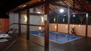 A modern outdoor pool area with glass walls and wooden flooring. - Pousada Banana Cipó (Santana do Riacho)