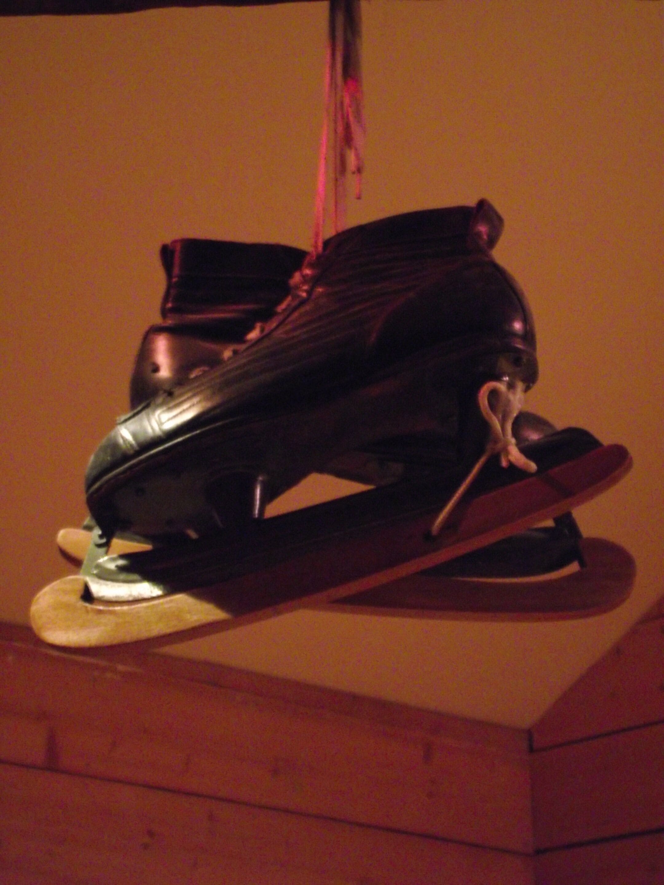 Un par de patines en línea negros colgados en una pared.