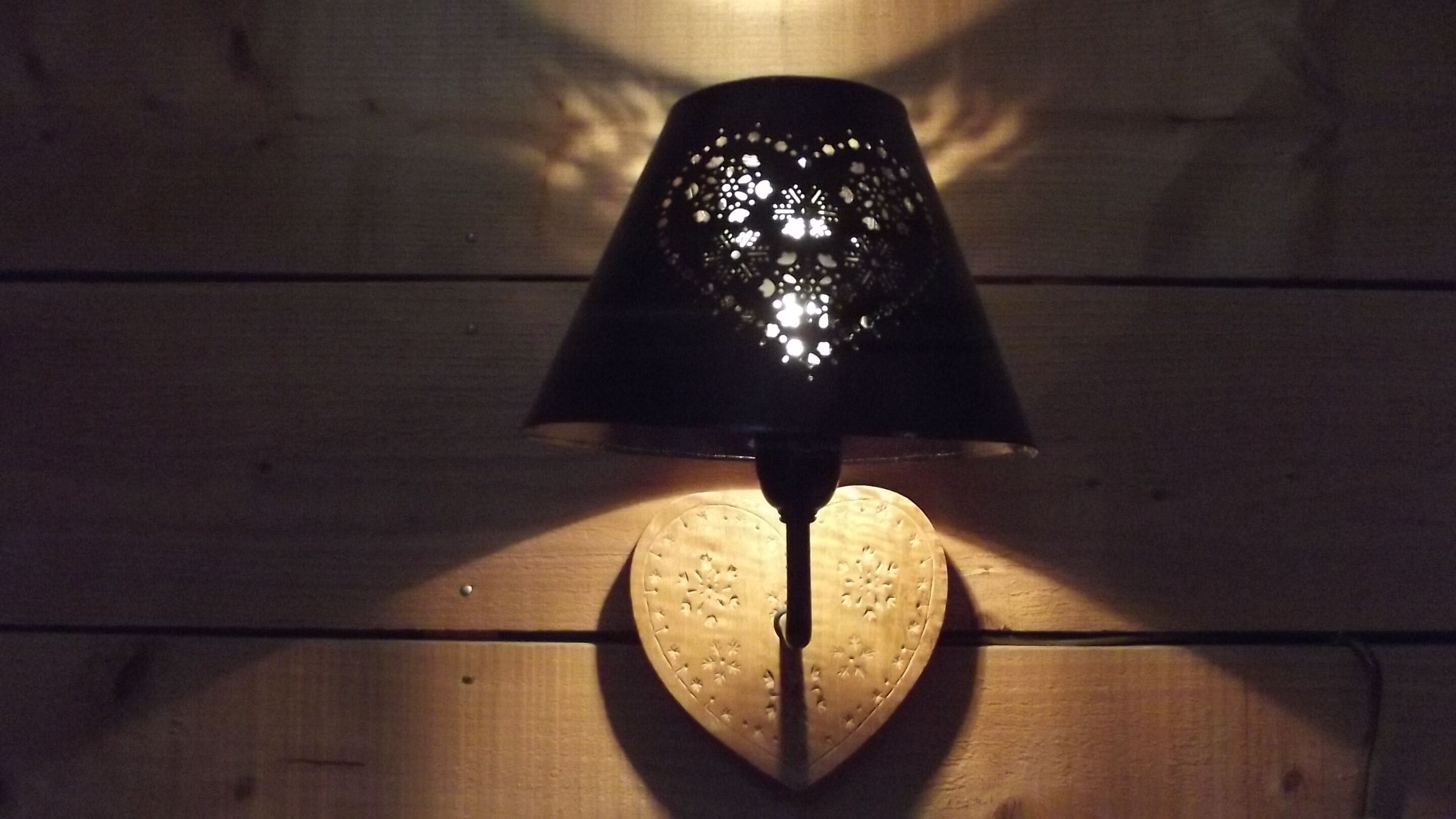 A heart-shaped light fixture on a wooden surface.