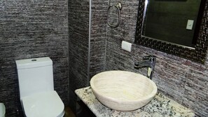 A bathroom with a white toilet, a marble sink, and a mirror with a black frame. - Unlimited Luxury Villa  LOS TULES (Puerto Vallarta)