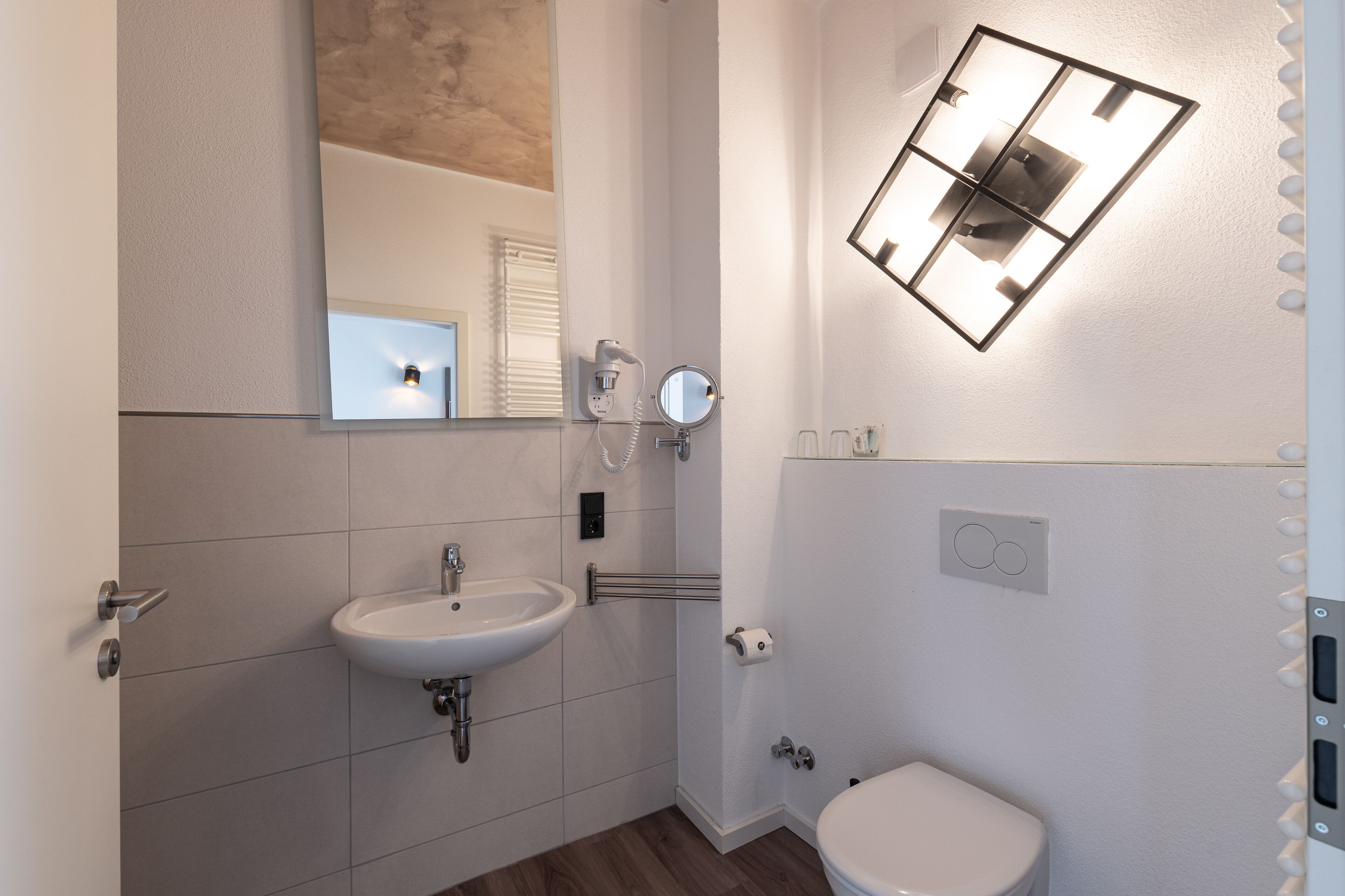 A bathroom with a sink, mirror, and toilet.