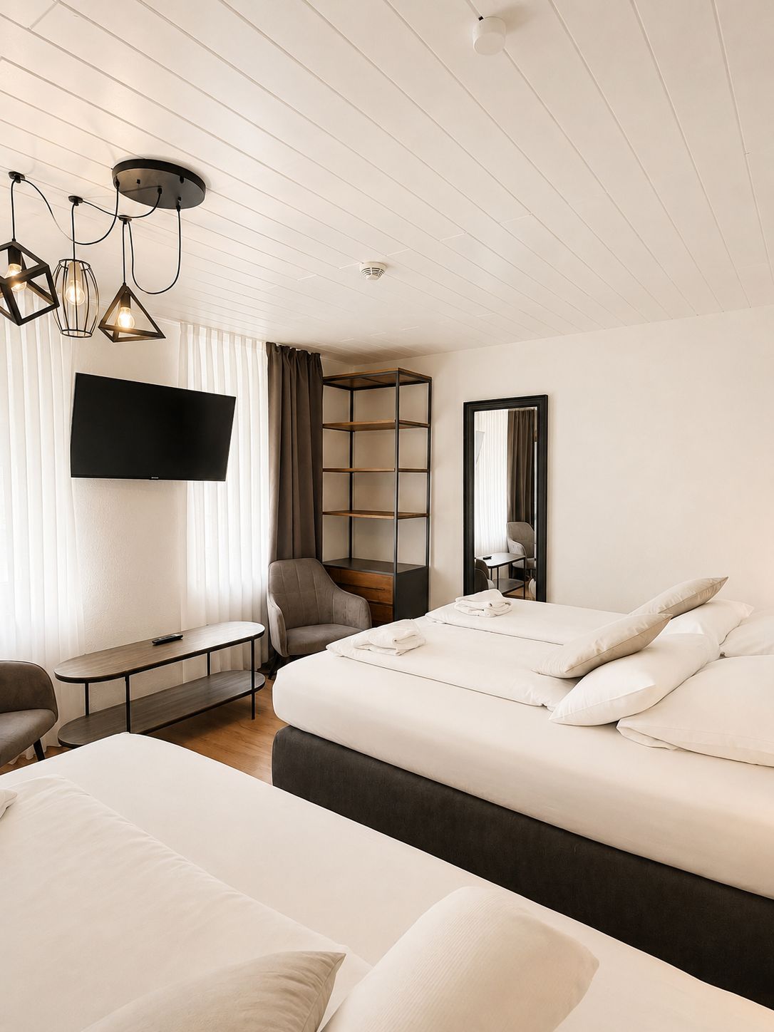 Une chambre d’hôtel comprenant un lit, un bureau, une chaise, une télévision et une bibliothèque.