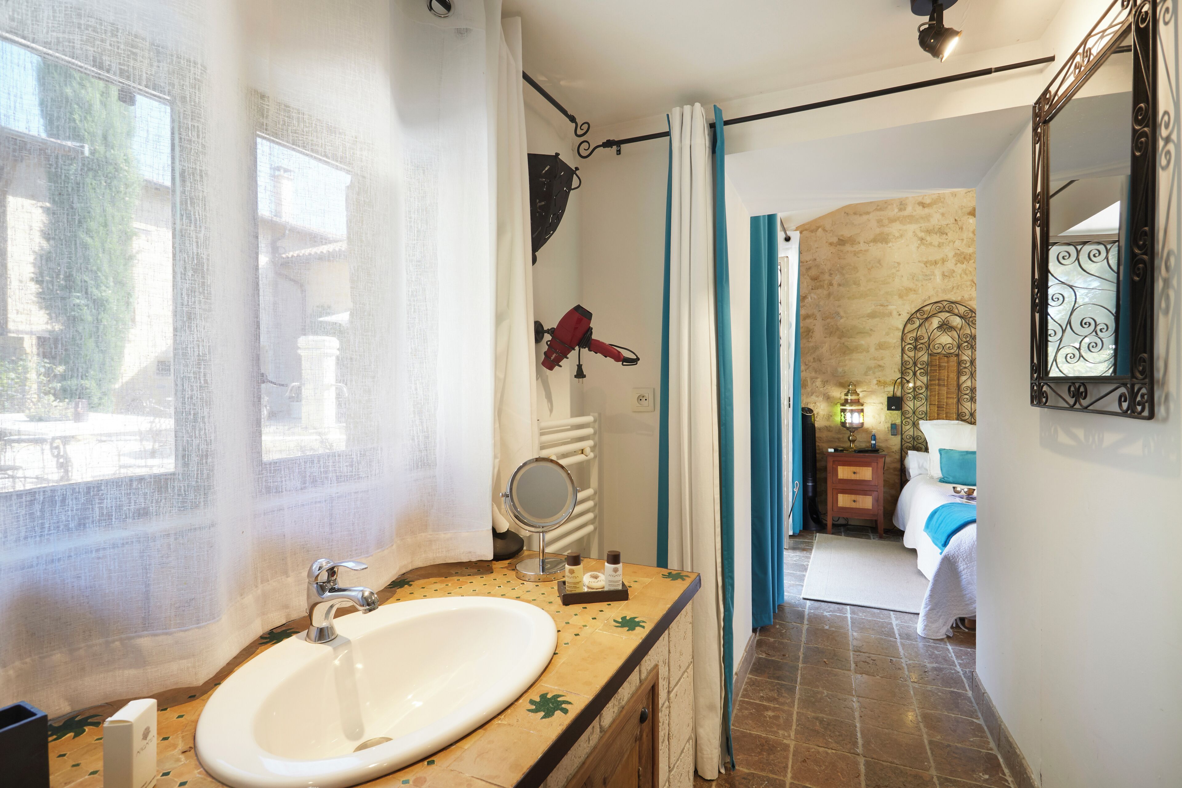 Une salle de bain équipée d’un lavabo, d’un miroir et d’une zone douche.