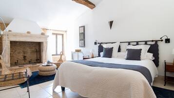Une chambre avec un grand lit, une cheminée et une vue sur l’extérieur.