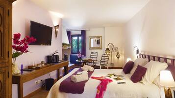 A hotel room with a bed, a desk, a TV, and a window with curtains.