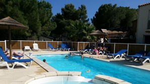 Una piscina con sillas de descanso y un jacuzzi.