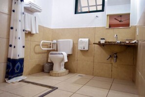 A small bathroom with a toilet, a sink, and a shower curtain. - Pousada Villa Harmonia (Paraty)