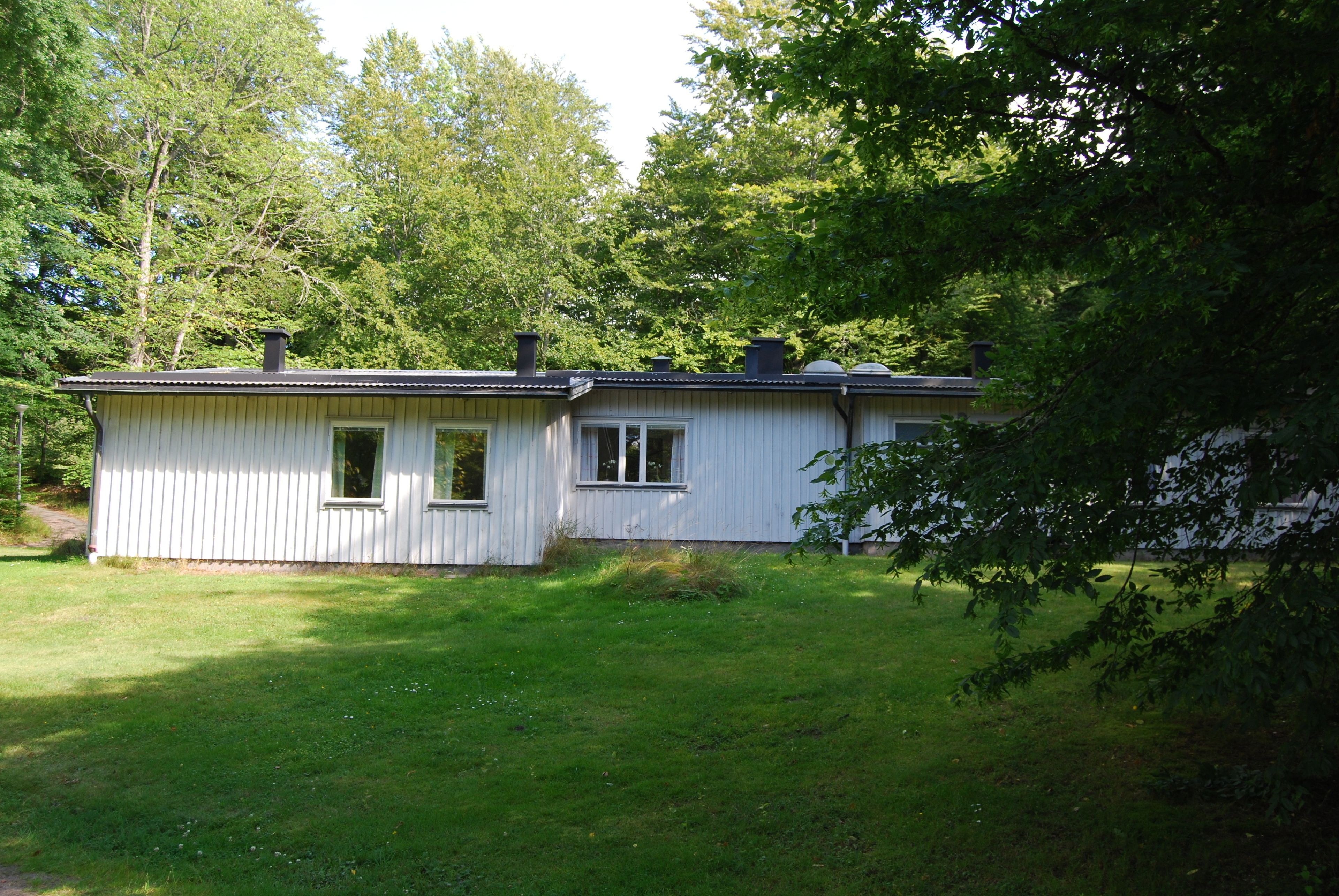 A single-story house with a gabled roof, a front door, and a small porch.