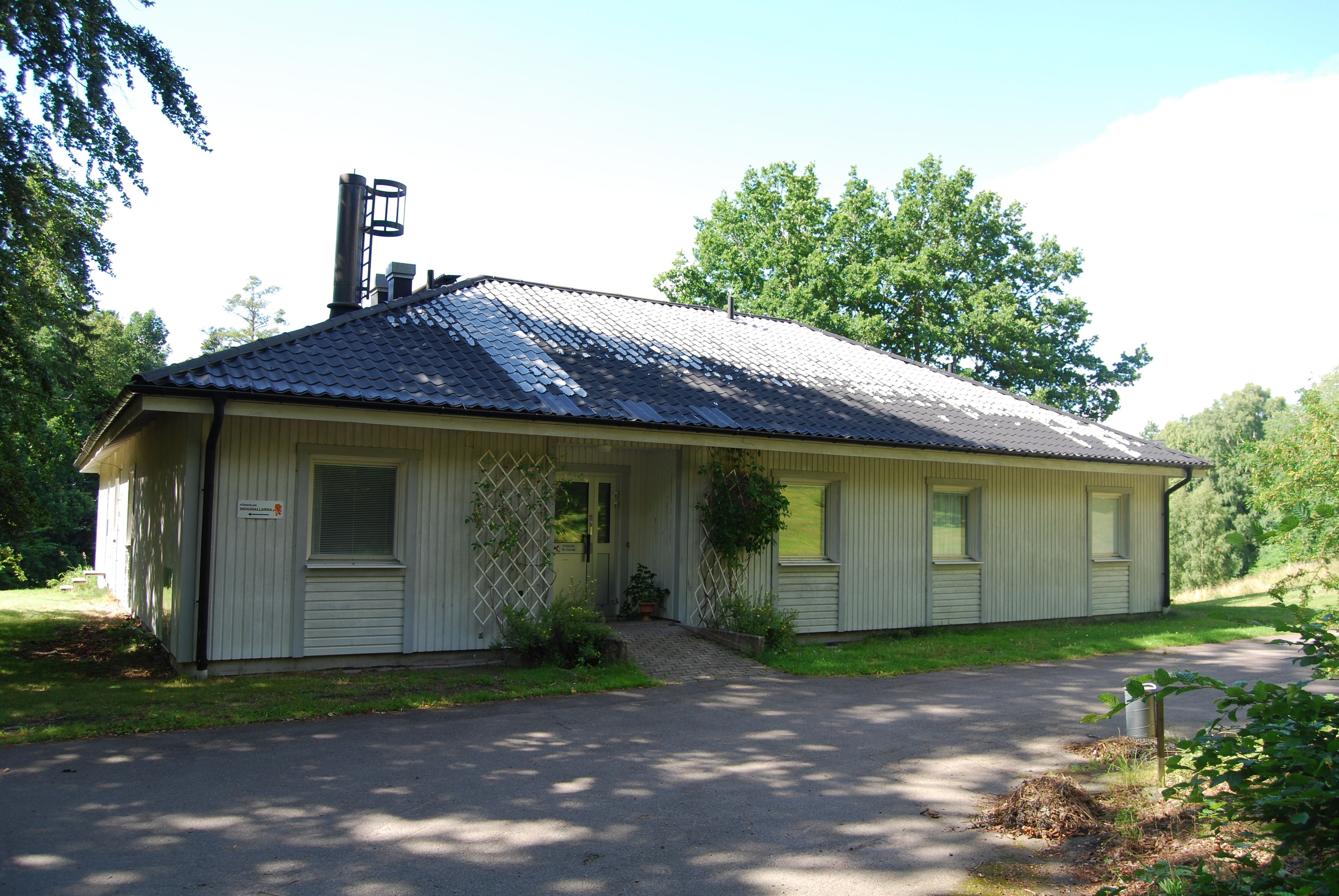 A single-story building with a metal roof, a front door, and a small porch area.
