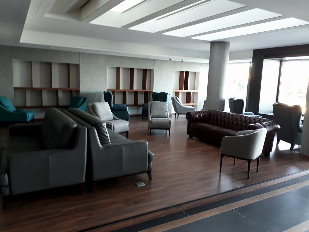 Una sala moderna con un sofá modular, sillones y un sofá de cuero.