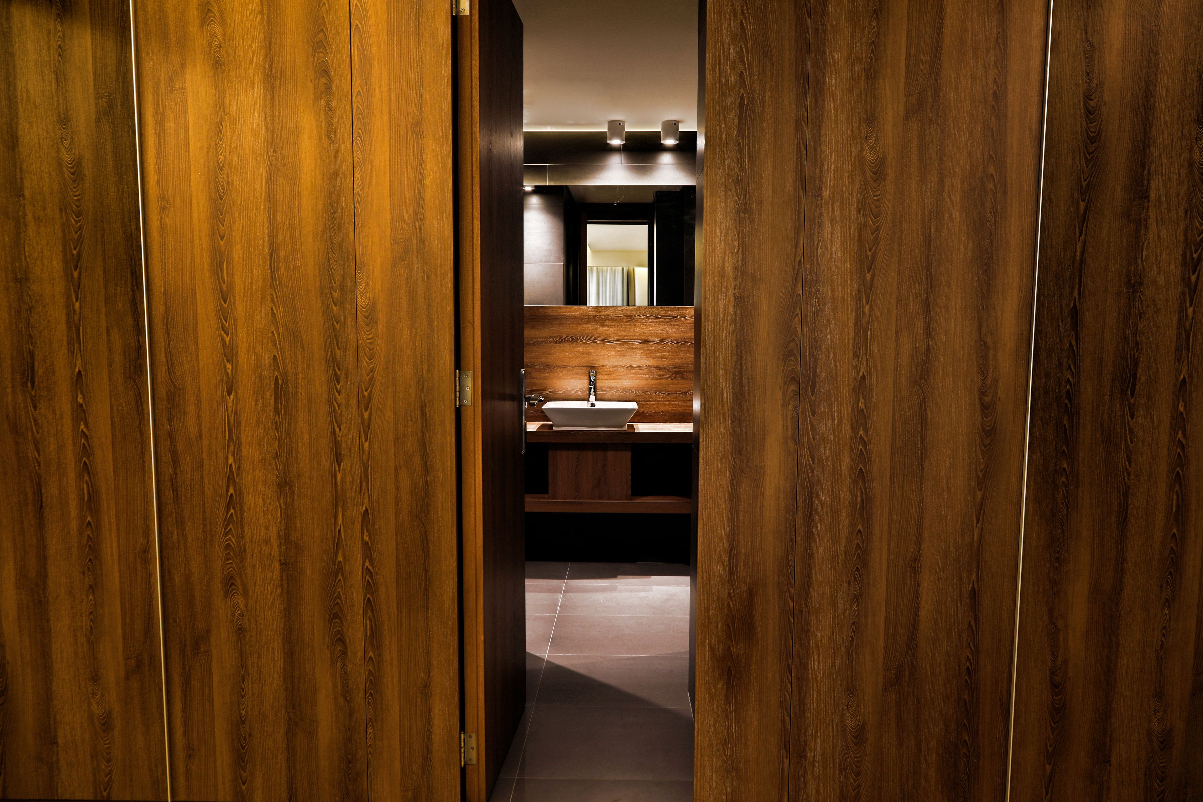 Une salle de bain aux murs lambrissés, avec un lavabo et un miroir.