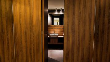 Une salle de bain aux murs lambrissés, avec un lavabo et un miroir.