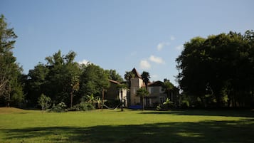 A large house with a spacious lawn and surrounding trees.
