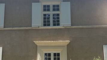 A building with a symmetrical facade, a central entrance with a double door, and two chimneys on the roof.