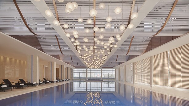 Piscina interior moderna com piso refletivo, fileiras de espreguiçadeiras e teto com luminárias esféricas penduradas.