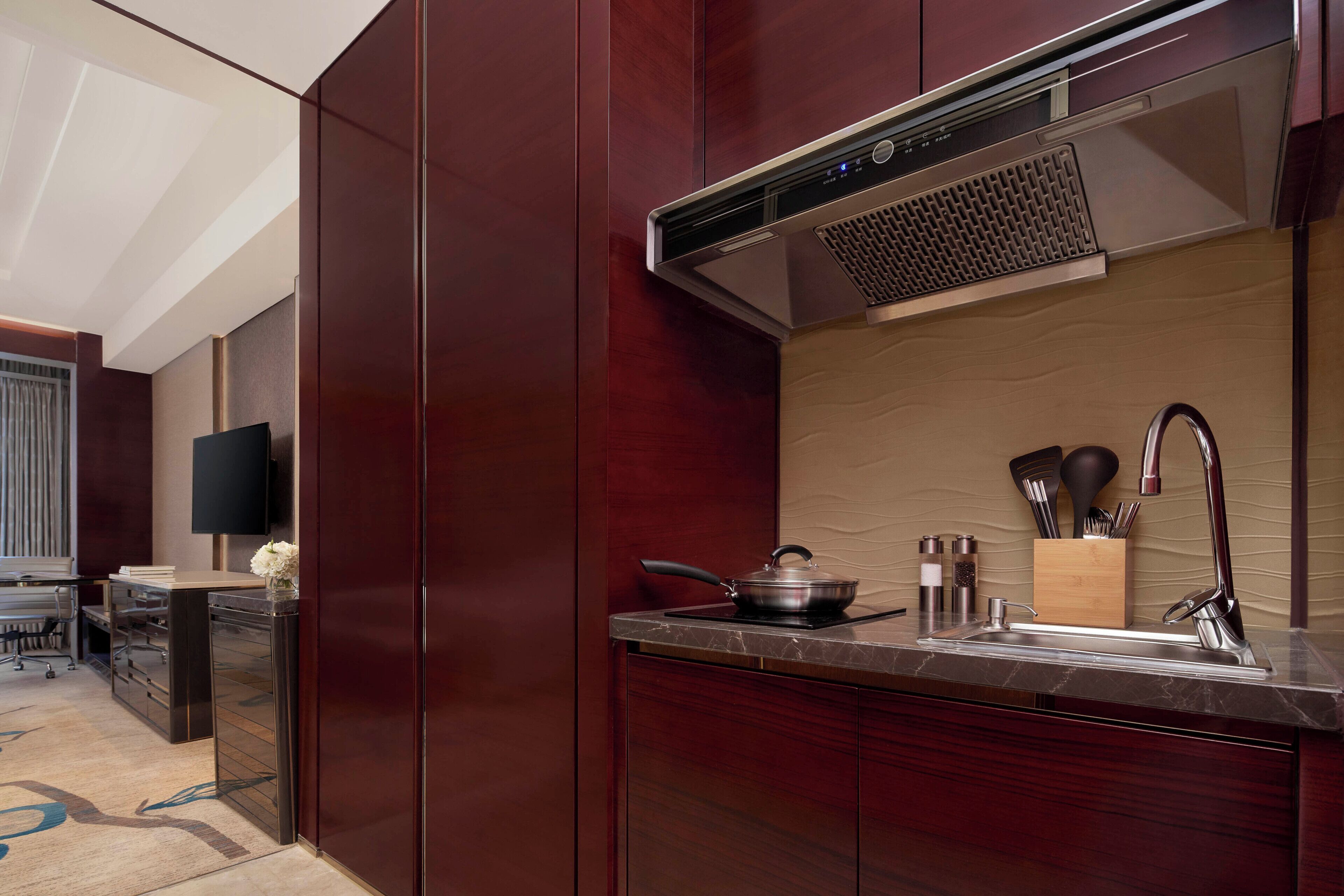 A modern kitchen with a built-in stove, a sink, and a range hood.