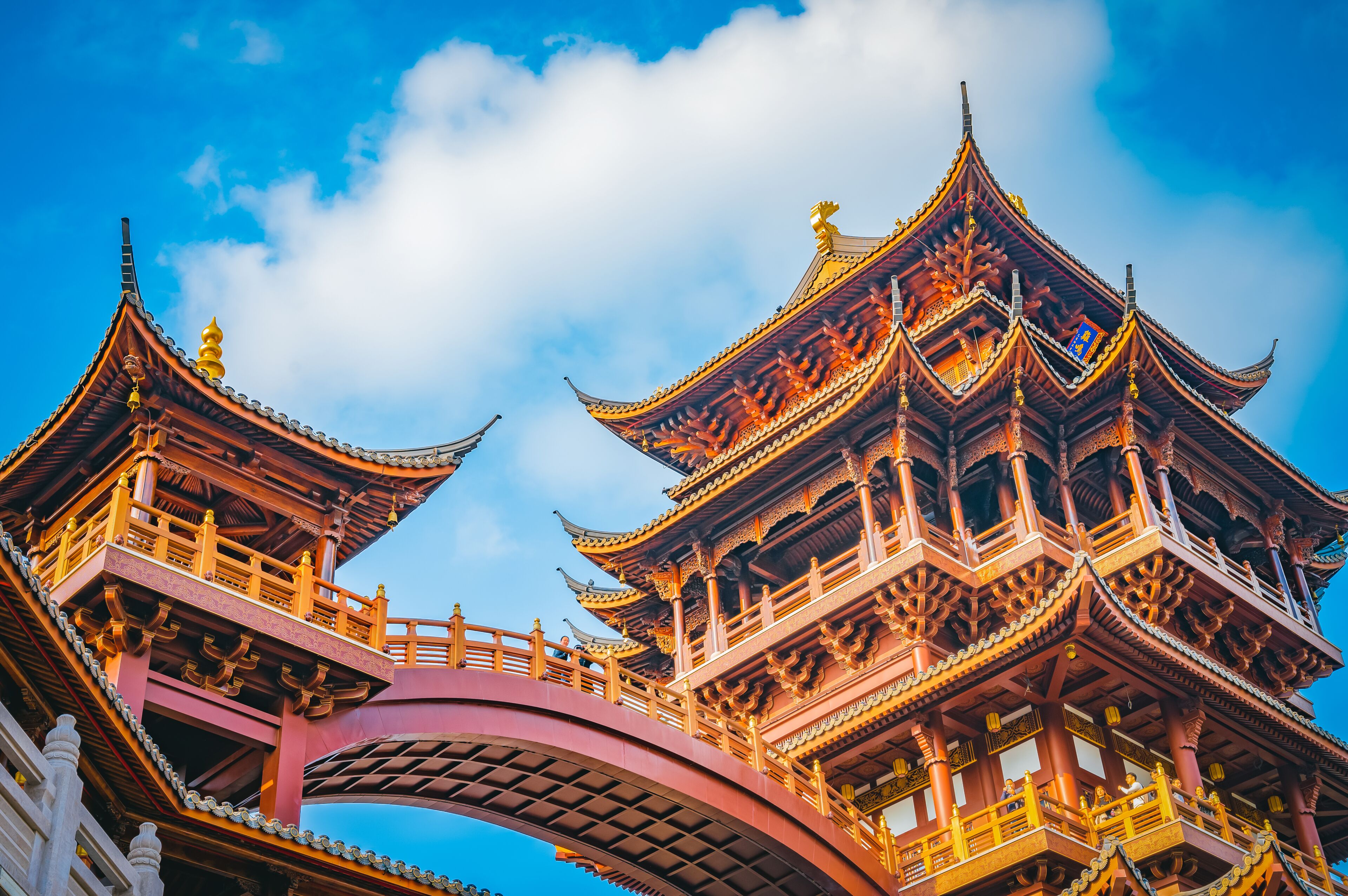 Un edificio tradicional en estilo pagoda, con varios niveles, y un puente curvo que lo conduce.