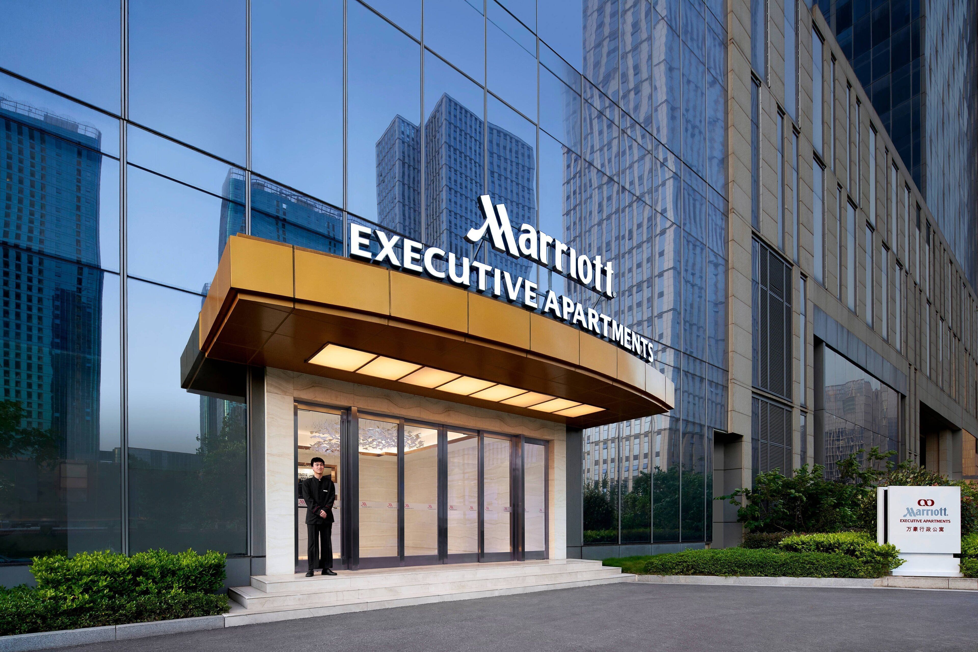 Edificio de Marriott Executive Apartments con fachada de vidrio moderna y vistas despejadas de los edificios altos circundantes.