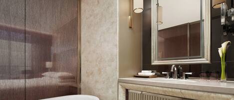 Un baño moderno con un espejo grande, una bañera y un mueble de tocador con lavabo y toallero.