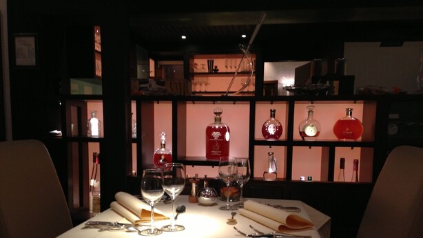Une table dressée avec des verres à vin, une bouteille de spiritueux et un stéthoscope.