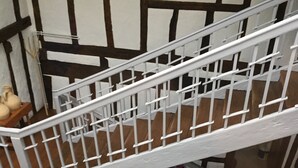 Un escalier avec des rampes blanches menant à l’étage supérieur.