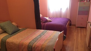 Une chambre avec deux lits, une commode et une fenêtre avec des rideaux.
