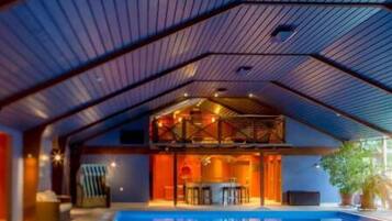 Una piscina techada, sillones reclinables de piscina