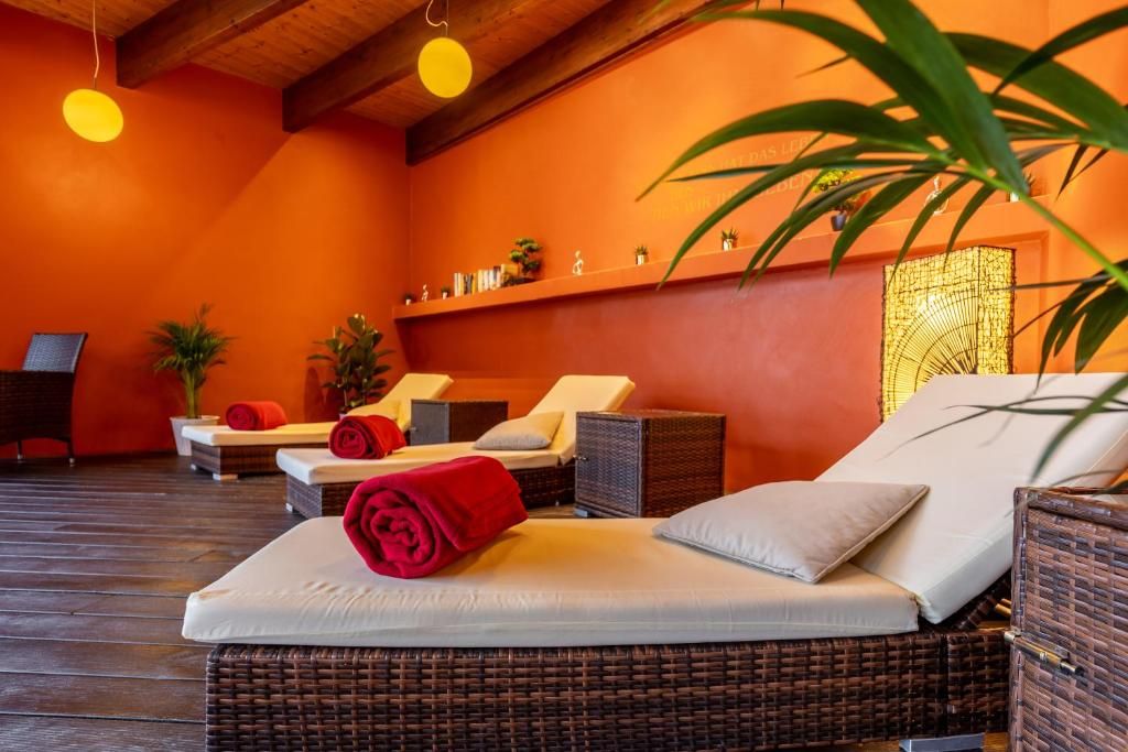 A room with wicker furniture, a red towel, and a wall-mounted shelf with plants.
