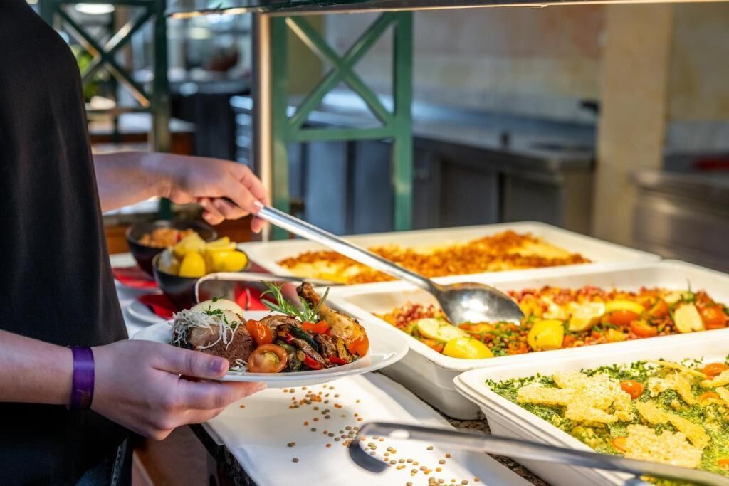 A buffet setup with various dishes, including a plate with a meat dish and a casserole.