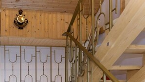 Un intérieur en bois agrémenté d’un escalier en métal, d’une horloge murale et d’une rampe décorative en métal.