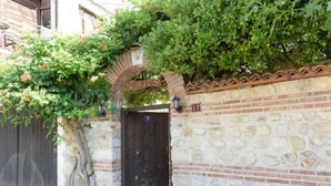 Un mur de pierre surmonté d’une arche en briques, sur laquelle on peut lire l’inscription « KIRIDS » et le chiffre « 17 ».