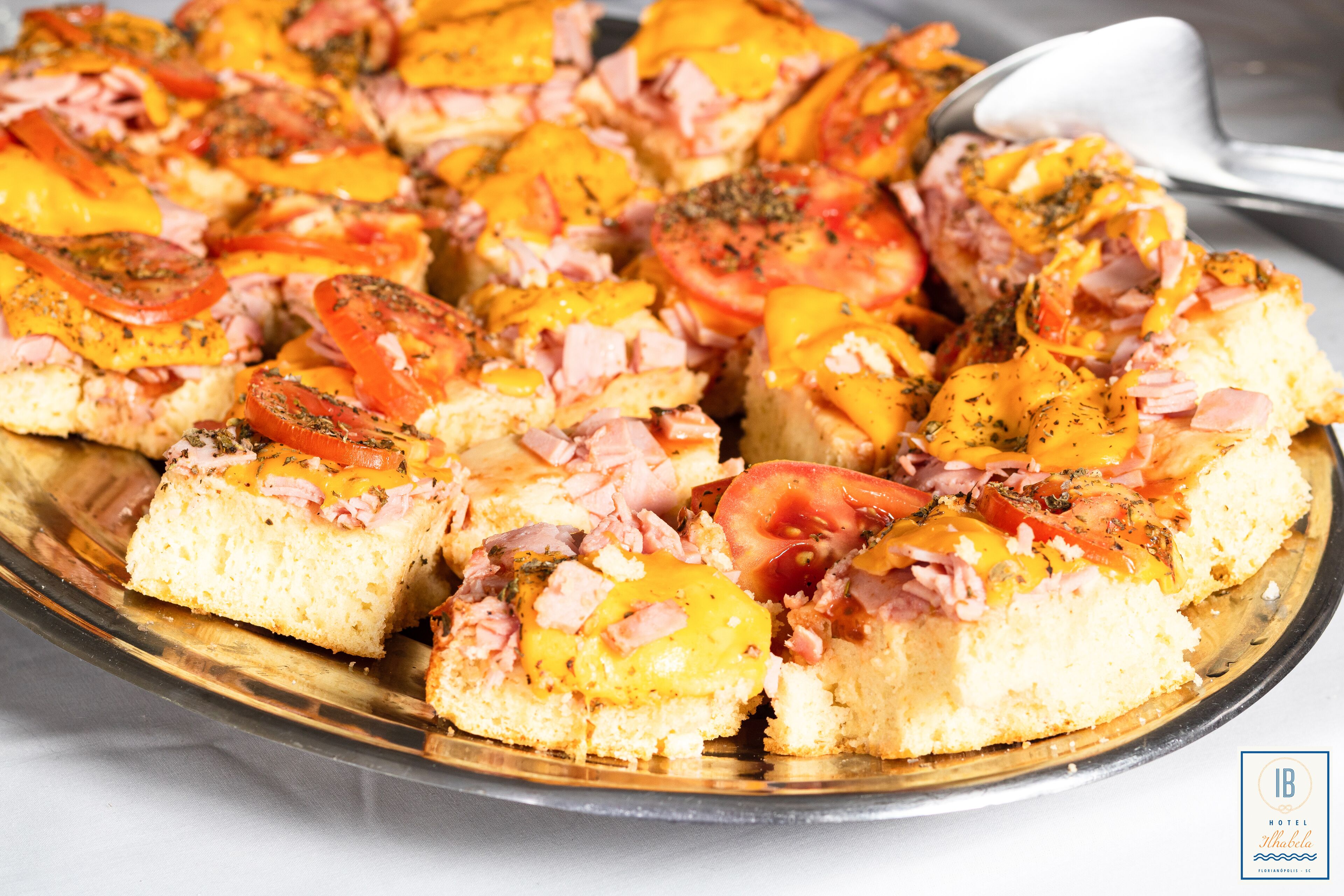 A plate of food with bread topped with tomatoes, cheese, and ham.