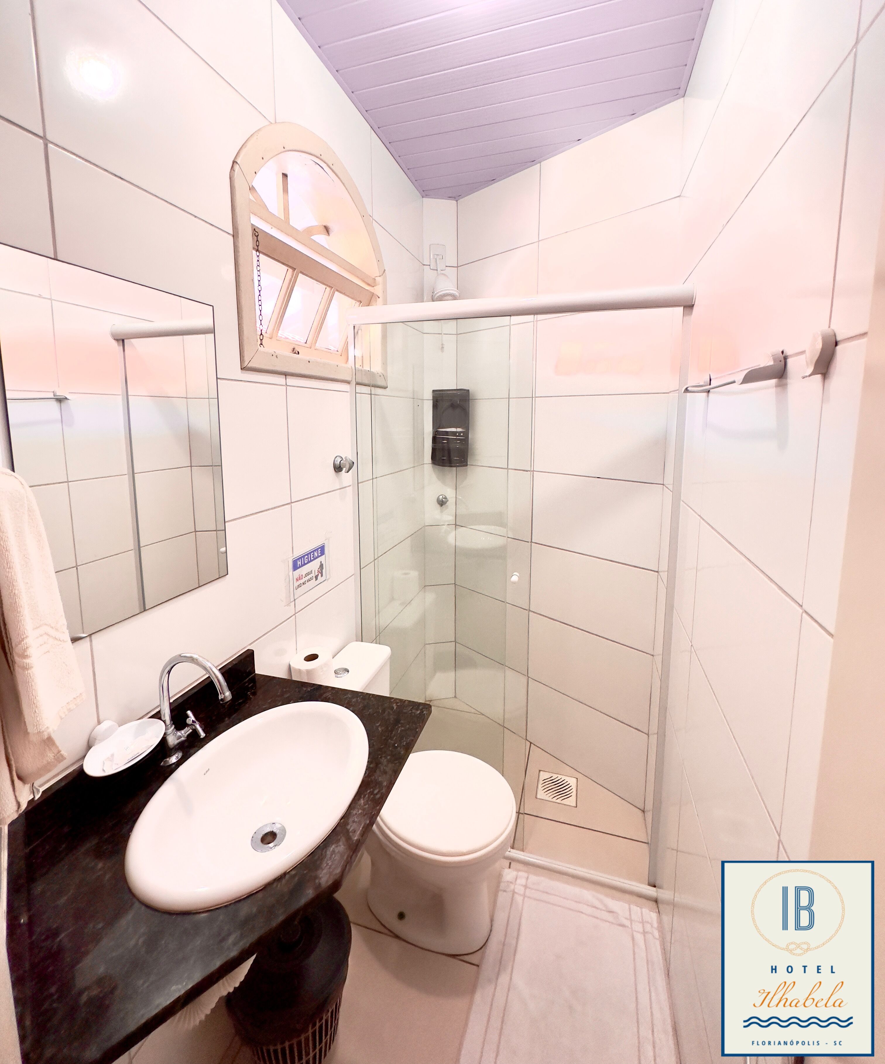 A modern bathroom with a glass-enclosed shower, a sink with a marble countertop, and a toilet.