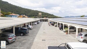 Un aparcamiento con varios coches y un corredor cubierto.